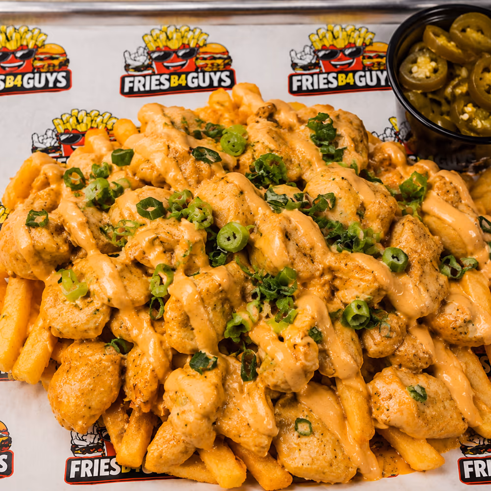 Halal chicken loaded fries under bang bang sauce with green onions and a side cup of jalape&ntilde;os