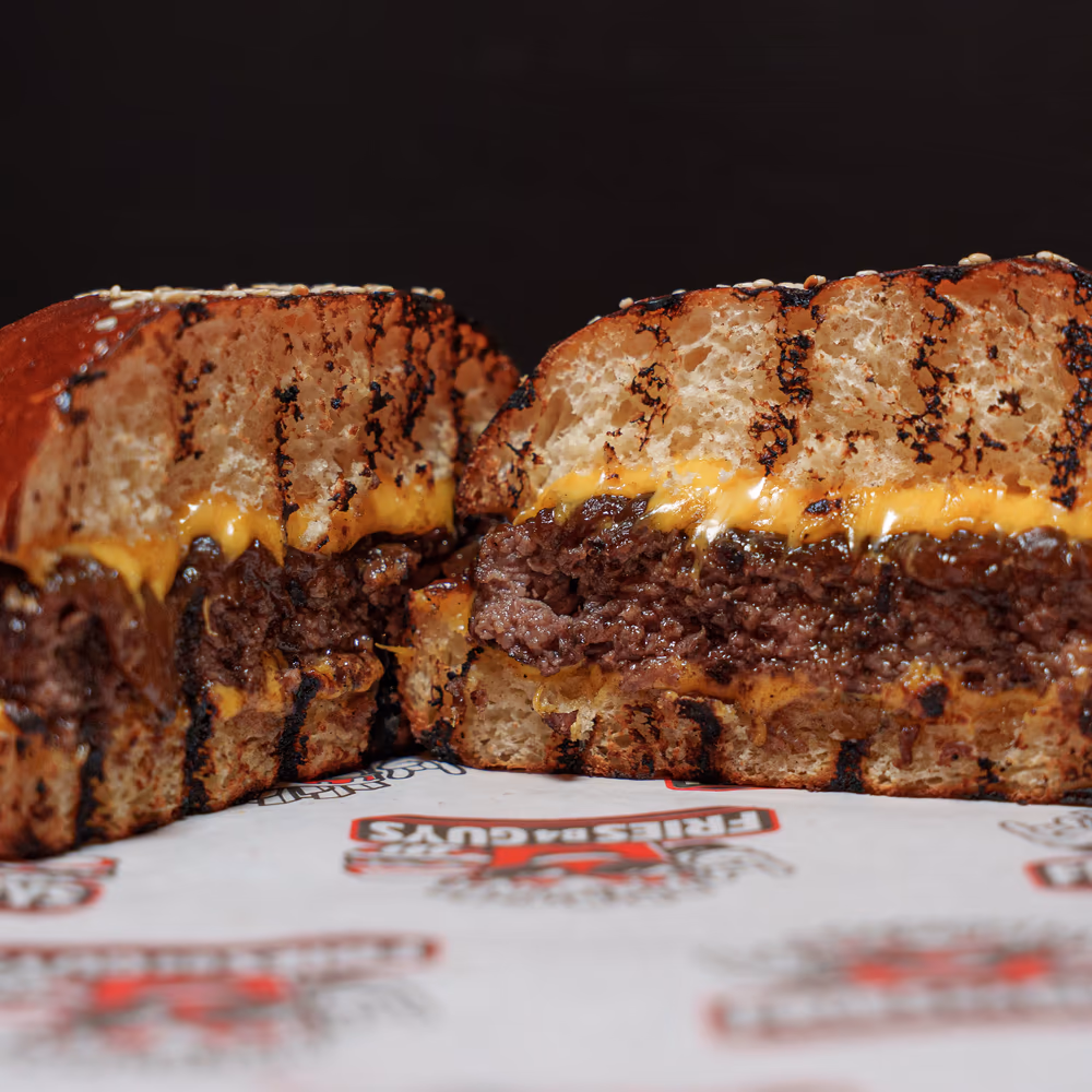 The FBG Burger cut in half, melted American cheese and caramelized onions on a sesame bun