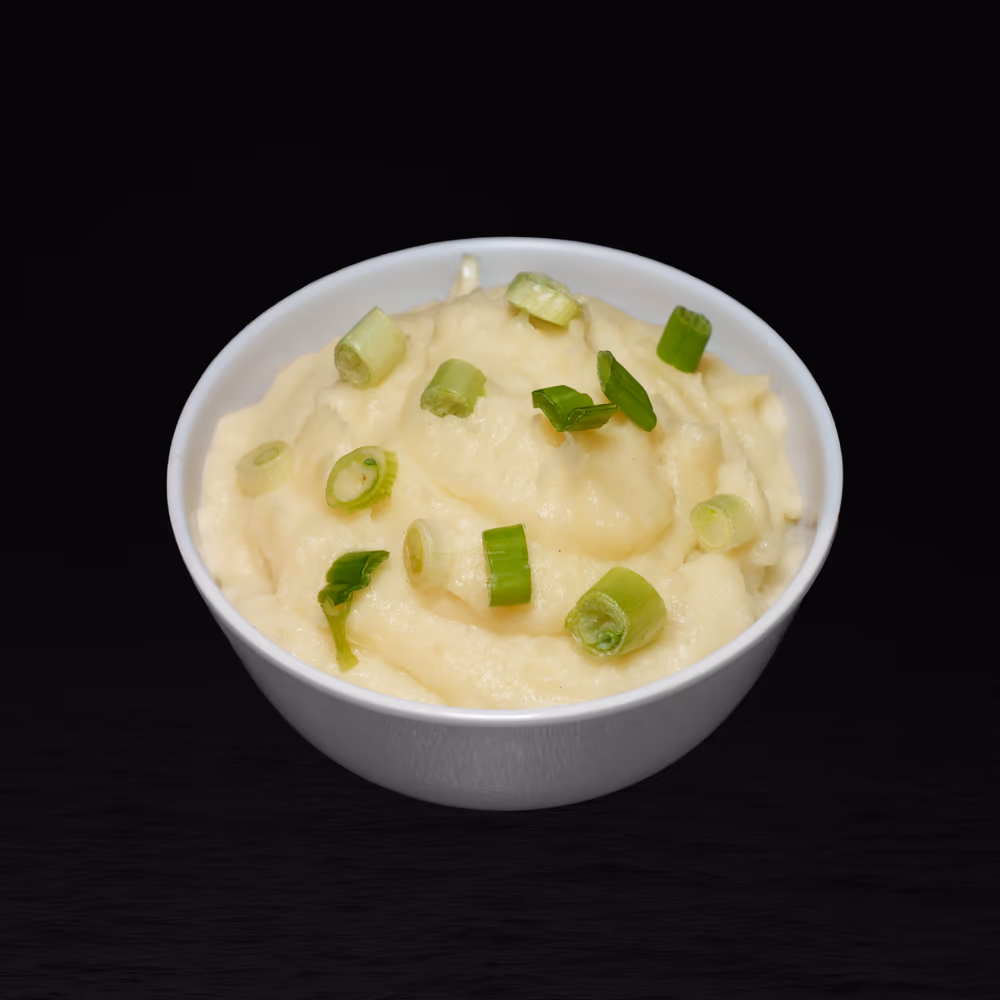 Bowl of classic mashed potatoes topped with green onions
