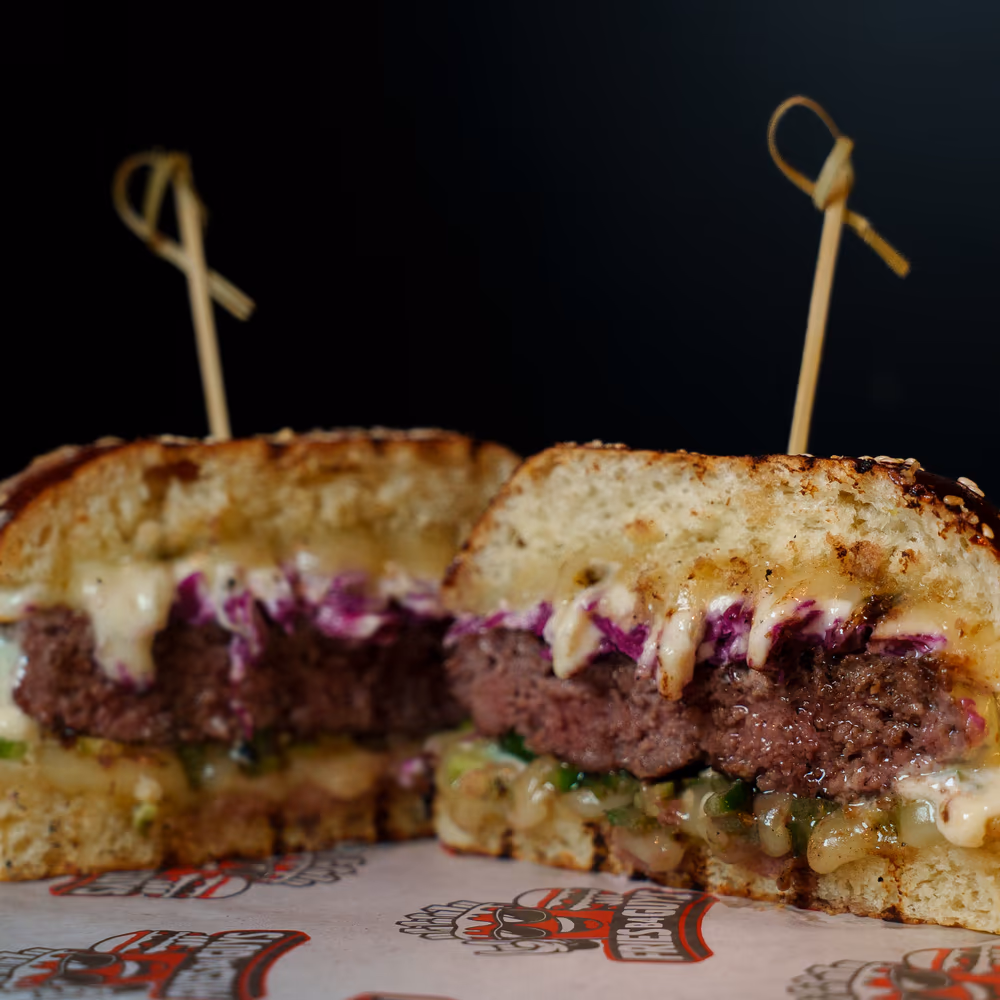 The Midnight Fire cut in half, purple cabbage and garlic sauce on a sesame bun